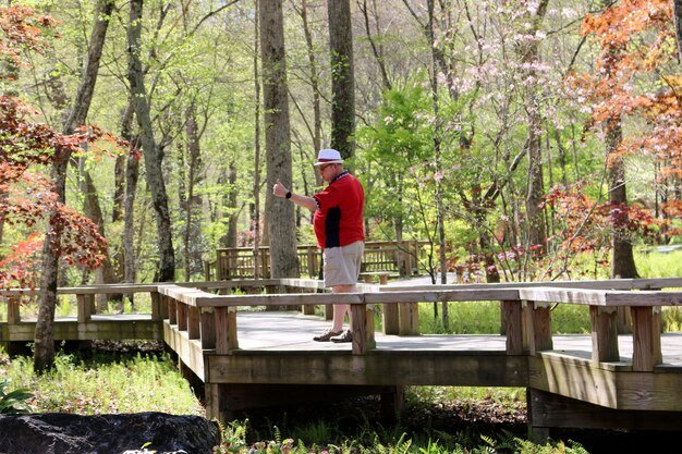 mature-man-standing-footbridge-forest_1048944-29918627