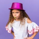 annoyed-little-caucasian-girl-with-violet-party-hat-blowing-party-whistle-isolated-purple-wall-with-copy-space_141793-97372