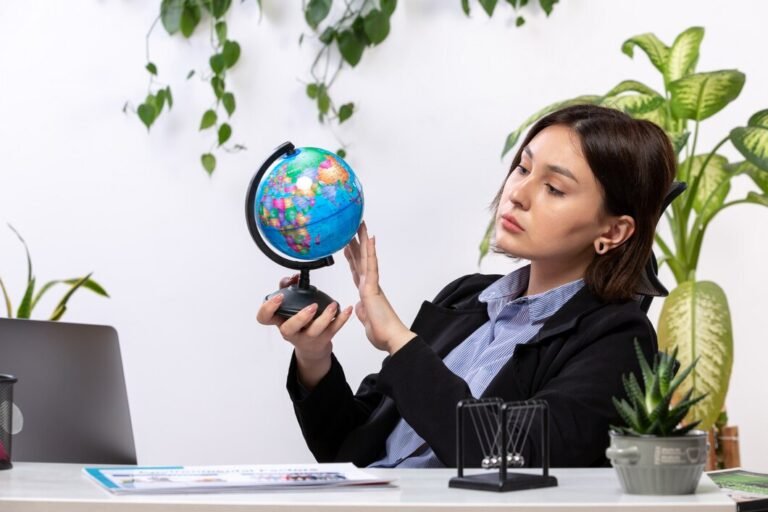 front-view-beautiful-young-businesswoman-black-jacket-blue-shirt-observing-little-globe-front-table-business-job-office_140725-15842