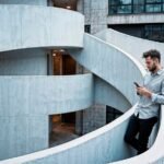 man-using-smartphone-curved-concrete-architectural-settings_24972-2890